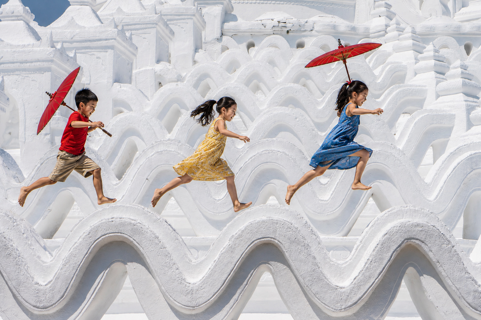 Children leaping across a white pagoda