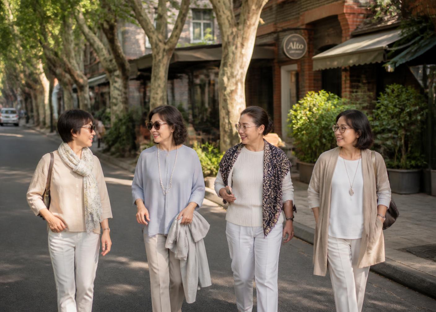 Four women in their fifties walking together along a plane-tree lined lane in Shanghai's former French Concession